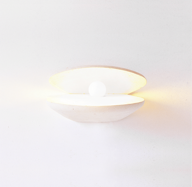 Applique con luce accesa in pietra leccese a forma di perla